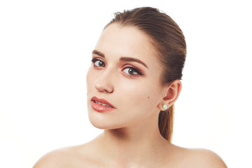Close up shot of beautiful lovely young woman with make up and healthy pure skin poses against white studio background, demonstrates her beauty and well done make up. Skin care concept