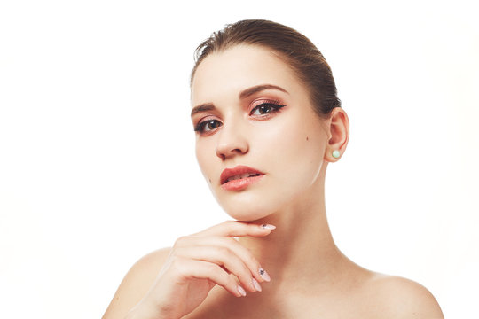 Beautiful young female with make up, poses nuse against white background, has mysterious expression, has healthy pure skin and attractive look. People, skin care, beauty and appearance concept