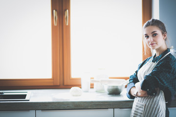 Fototapeta na wymiar Young woman standing near desk in the kitchen
