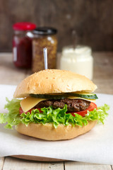 Homemade hamburger with fresh vegetables served with various sauces.