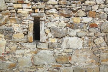 Irregular fieldstone wall with an arrow slit