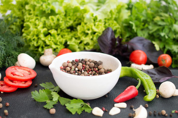 spice mix in a white bowl and fresh vegetables and herbs