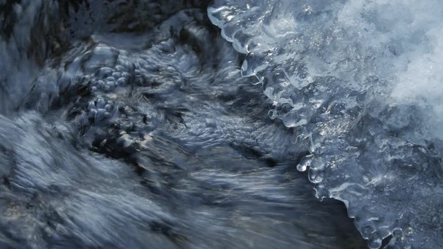 Frozen Mountain Stream. Under the ice build up running fresh water mountain stream close-up.
