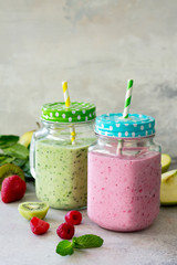 Mix fresh fruit smoothie and green smoothies on a gray stone or slate background. The concept of proper nutrition and health or detoxification. Copy space.
