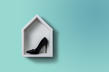 High heels, the shoe lies in a white house hung on the wall. Fashion concept, catwalk. Online store, fashion store, sale of shoes. Pastel, green background.Footwear. Female shoes.