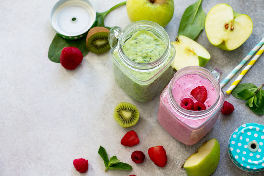 Mix fresh fruit smoothie and green smoothies on a gray stone or slate background. The concept of proper nutrition and health or detoxification. Copy space.