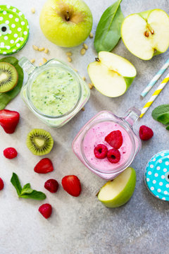 Fresh fruit smoothie and green smoothies on a gray stone or slate background. Healthy vegan food concept. Copy space, top view flat lay background.