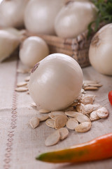 Ripe onion and pumpkin seeds on table, closeup