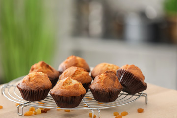 Cooling rack with tasty cupcakes on table