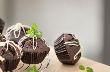 Cooling rack with tasty chocolate cupcakes on table