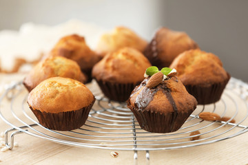 Cooling rack with tasty cupcakes on table