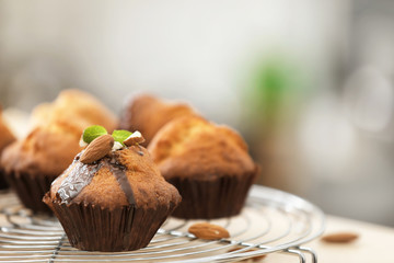 Cooling rack with tasty cupcakes on table