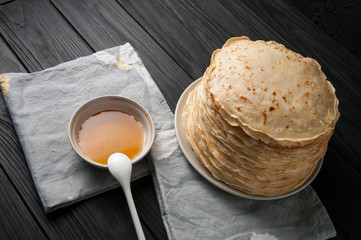 Homemade pancakes with honey and walnuts, vintage white plate, dipper, dark wooden table