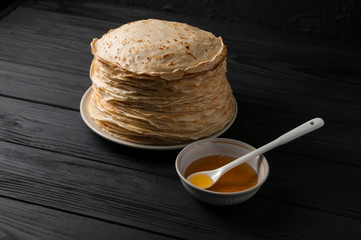 Homemade pancakes with honey and walnuts, vintage white plate, dipper, dark wooden table
