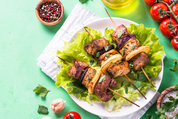 Grilled shish kebab or shashlik on green table.