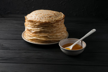 Homemade pancakes with honey and walnuts, vintage white plate, dipper, dark wooden table