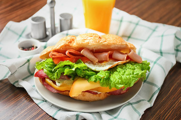Tasty croissant sandwich on plate, closeup