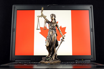 Symbol of law and justice with Canada Flag on laptop. Studio shot.