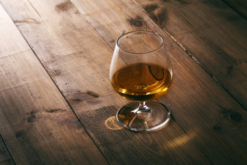 Glass of cognac on the wooden table