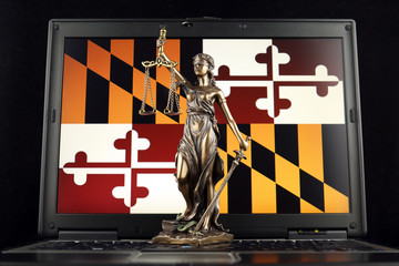 Symbol of law and justice with Maryland State Flag on laptop. Studio shot.