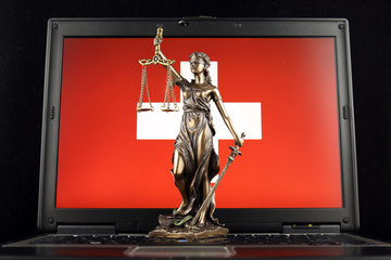Symbol of law and justice with Switzerland Flag on laptop. Studio shot.