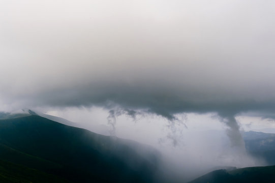Storm rainy clouds above mountains. Apocalypse fantasy fabulous sky. Beautiful windy dramatic cloudscape at nature. Picturesque scenic view outdoor. Travel in wild territory. Discover rocky hills.