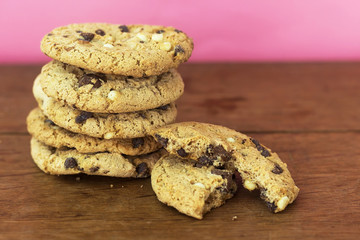 homemade white and black chocolate cookies on wood table with pink background