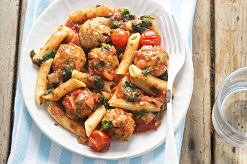 Pork meatballs with pasta, cherry tomatoes, spinach in tomato sauce 