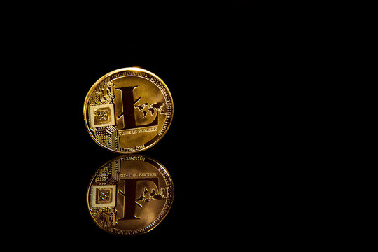 Criptocurrency concept golden litecoin coin on blak mirror surface