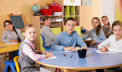 pupil with teacher sitting at table and studying