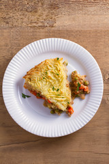 Traditional shepherd pie - popular dish in Ireland. Beef meat, mashed potato, cheese, carrot, onion and green peas casserole. View from above, top