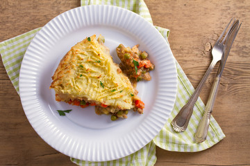 Traditional shepherd pie - popular dish in Ireland. Beef meat, mashed potato, cheese, carrot, onion and green peas casserole. View from above, top