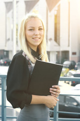 young business woman with clipboard standing on the balcony of the office