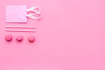 Gift concept. Sweets, paper bag for gift on pink background top view copy space