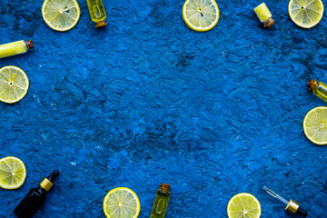 Natural cosmetics set with fresh lemon and organic oil on blue table background top view mock up