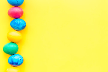 easter celebration with colorful eggs on yellow background top view mock-up