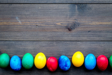 Easter celebration with colorful eggs. Wooden background top view mock up