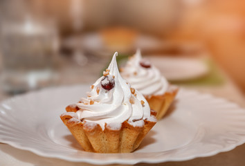 Appetizing baked basket with lemon mousse and whipped cream, whipped egg whites. Food on a white plate for the culinary site. Copy space.
