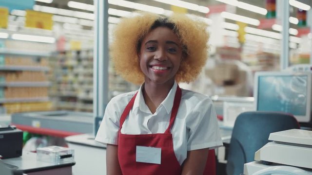 Portrait african american woman blond hair works at supermarket cash desk look camera smiling happy girl fruit technology grocery market store black retail indoors consumer vegetables slow motion