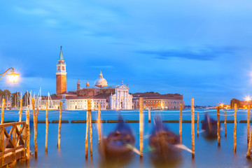 San Giorgio Maggiore church and gondolas in Venice, Italy during blue hour sunrise. Focus on the church.