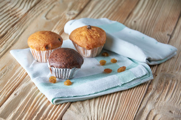 Chocolate and vanilla muffins with nuts on wooden background, selective focus