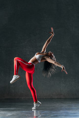 Young beautiful female dancer is posing in the studio