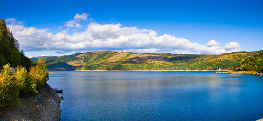 Panorama view over Izvorul Muntelui lake and dam with autumn scenery and beautiful blue sky