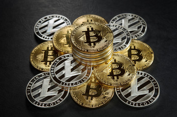 Pyramid from bitcoins and litecoins with stack of coins on the top.