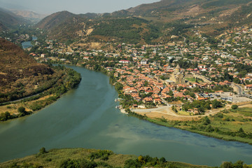 Fototapeta na wymiar Top view on the Mtskheta city and the Aragvi river confluence with mountains on the background. Georgia 2017.