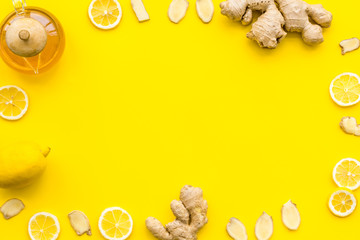 Warming tea with lemon and ginger. Cup, teapot, ginger root on yellow background top view copy space