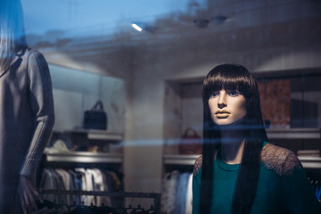Female mannequins inside fashion house window, fashionable shop