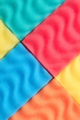 Colorful kitchen sponges background. Multicolored sponges for dish cleaning as wallpaper. Housekeeping and cleaning concept.