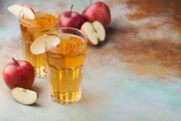 Two glasses of red Apple juice with mint and ice on an old rusty table. Soft drink on a blue background. With copy space