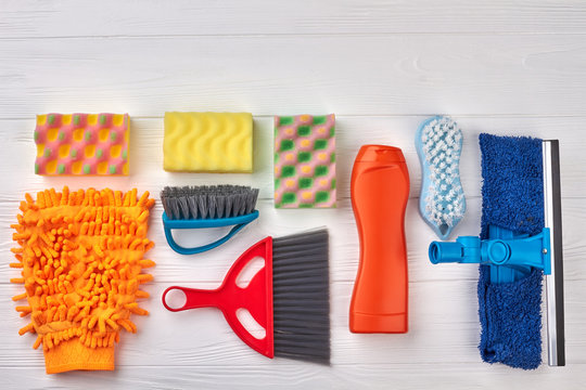 Flat lay house cleaning objects. Set of brushes and sponges for house cleaning on wooden background, space for text. Home cleaning concept.